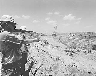 Barry Denton (l) shows a visitor around the Sandow Mine