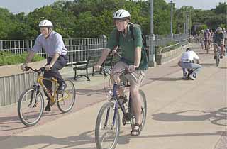 The FY2003 to-do list for the Transportation, Planning, and Sustainability Department includes the extension of the Pfluger Bridge (shown here being used by Daryl Slusher and Lloyd Doggett), along with parallel work on the Lance Armstrong Bikeway, Seaholm Master Plan, and Second Street corridor improvements. Meanwhile, the Public Works department will figure out what's wrong with the cracking concrete overlay on the bridge.