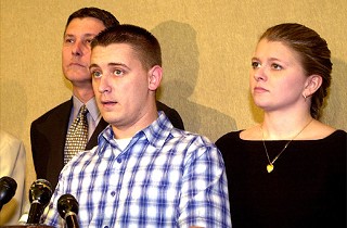 Maurice Pierce's wife, Kimberly, stands behind him as he addresses the media in January 2003, shortly after charges against him were dismissed.