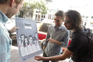 Party Down stars (from left) Ryan Hansen, Adam Scott, and Martin Starr admire the special limited edition poster designed by Scrojo for the event