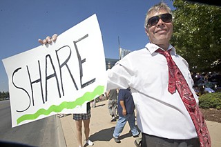 Jason Wolcott holds a sign that encourages a basic value.