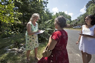 AGR block walker Jessica Ellison stands by while South Austin resident Suzanne Vignaud looks over a petition.