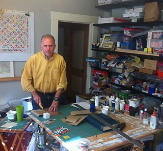 Durst's cutting table takes up the bulk of the floor space in his studio. To his left are his stacks of material.