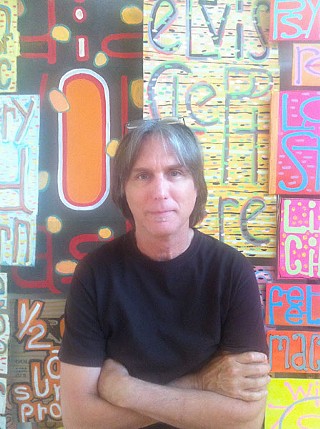 The artist in front of some of his work