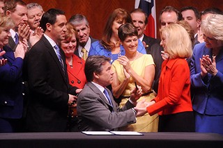 Gov. Rick Perry hands a pen he used to sign HB 2 into law to Rep. Jodie Laubenberg, House sponsor of the bill.