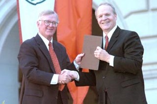 Commission of 125 Chair Kenneth Jastrow II (l) presents the report to UT President Larry Faulkner.