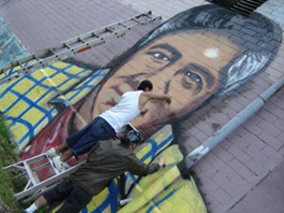 Artists Lucas Negrete and Juan Sarao working on the 
Chavez painting