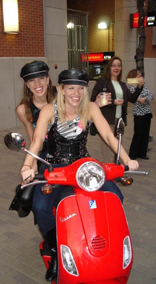 Glamour girls Maureen Staloch (front) and Christie Butterfield terrorize Second Street on the red Vespa that is being raffled for the Zach Scott fundraiser, Red, Hot and Soul.
