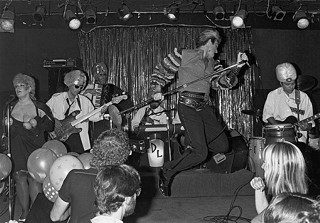 Dino Lee takes a flying leap onstage at Fitzgerald’s in Houston, where the White Trash Revue got banned because the audience stripped naked, 1985.