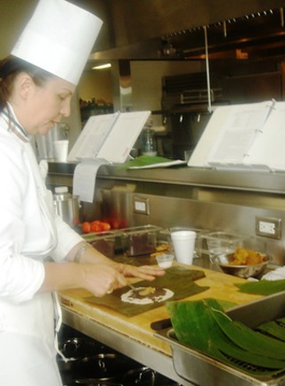 Chef/instructor Iliana de la Vega demonstrates proper tamale technique in the teaching kitchen of CIA San Antonio.