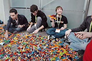 <a href=http://behance.com/><b>Behance.com</b></a> team members and South by Southwest registrants (l-r) Scott Belsky, Chris Henry, and Dave Stein rediscover their childhoods with a pile of LEGOs in a corner of the Austin Convention Center.