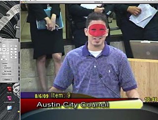 John Bush, sporting a mask, addresses the council.